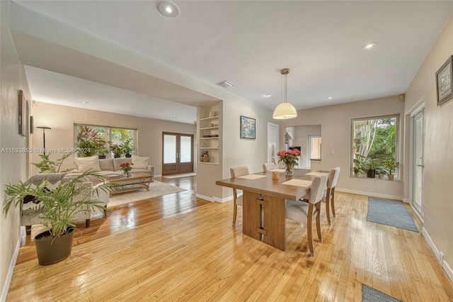 dining area with built in features, french doors, and light hardwood / wood-style flooring