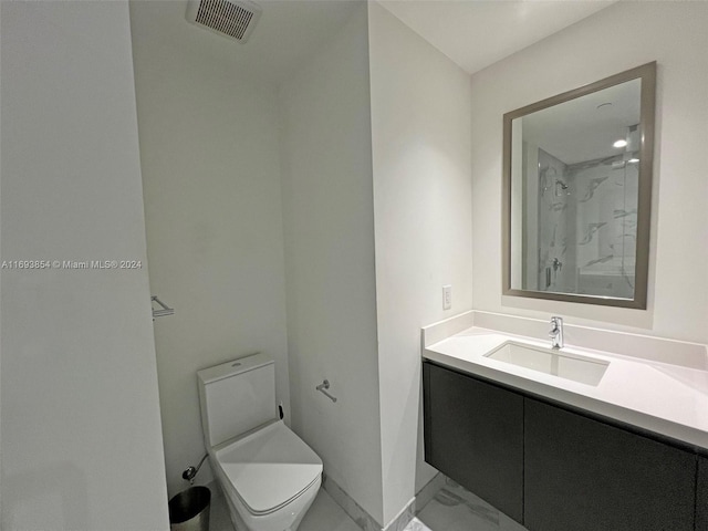 bathroom featuring a shower, vanity, and toilet