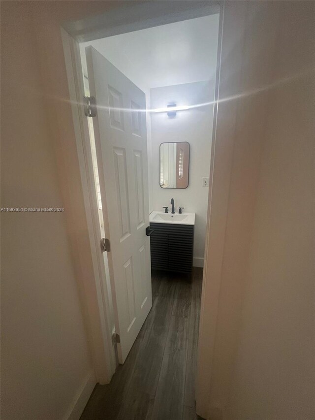 718 Whippoorwill Ln, Delray Beach, FL 33445 - hall with dark wood-type flooring, a sink, and baseboards