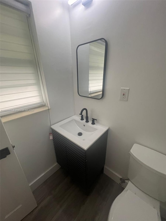 bathroom with vanity, wood-type flooring, and toilet