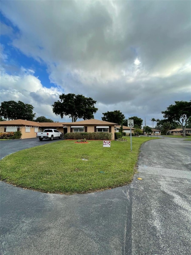 single story home featuring a front lawn