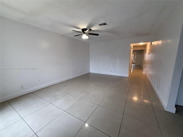 spare room with ceiling fan, light tile patterned flooring, and a textured ceiling