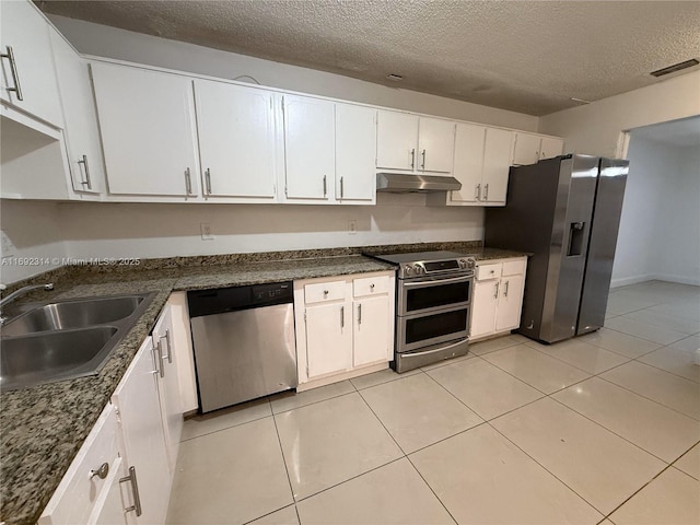 kitchen featuring white cabinets, appliances with stainless steel finishes, a textured ceiling, and light tile patterned floors