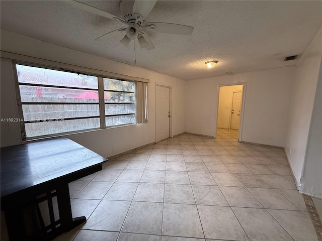 entryway with a textured ceiling, ceiling fan, and light tile patterned flooring