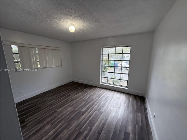 empty room featuring dark wood-type flooring and a textured ceiling