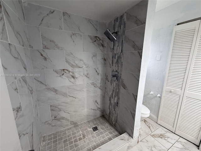 bathroom featuring toilet and a tile shower