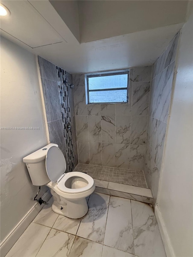 bathroom featuring toilet and tiled shower