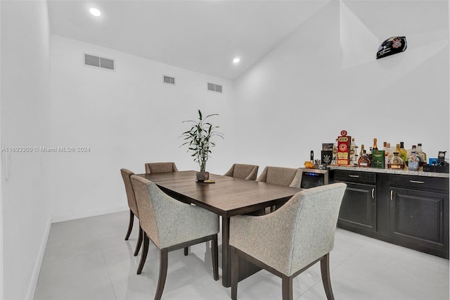 dining area featuring bar area and light tile patterned floors