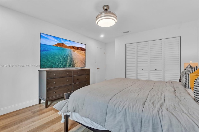 bedroom with light hardwood / wood-style floors and a closet