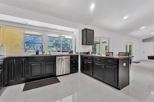 kitchen with kitchen peninsula, dishwasher, light tile patterned floors, and sink