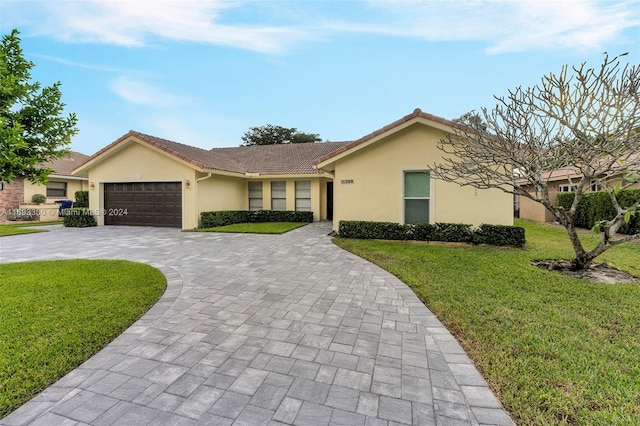 ranch-style house featuring a front lawn and a garage