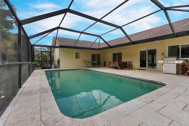 view of swimming pool featuring glass enclosure and a patio