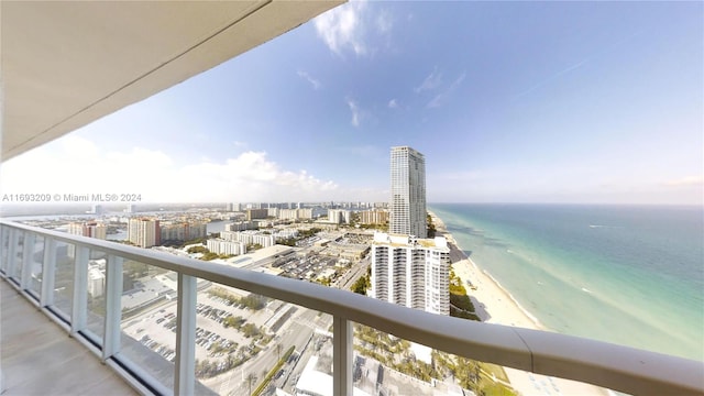 balcony with a water view and a view of the beach