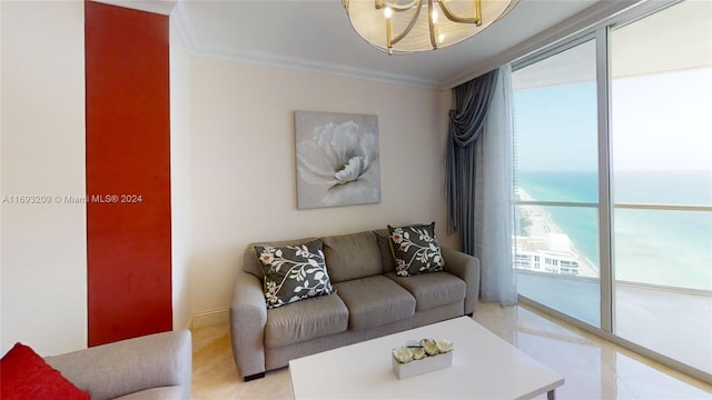 living room with crown molding, a water view, and an inviting chandelier