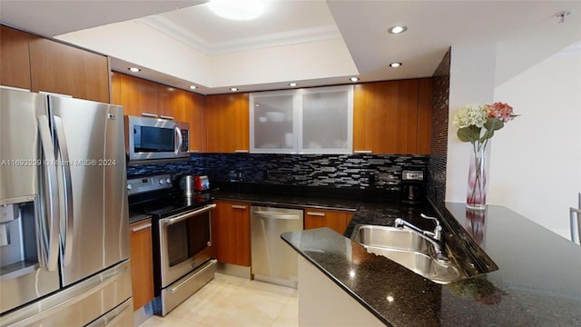 kitchen featuring sink, decorative backsplash, dark stone countertops, light tile patterned floors, and stainless steel appliances