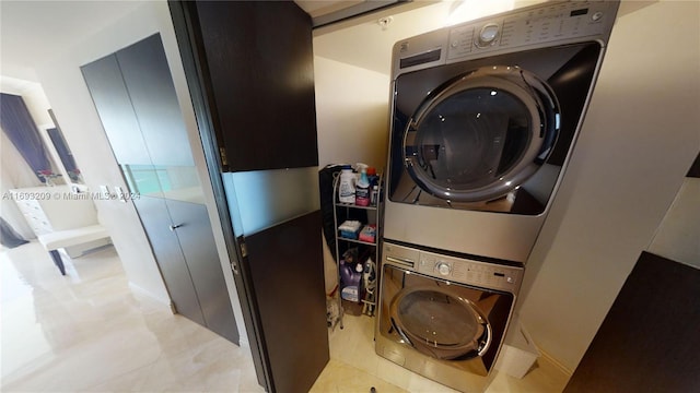 washroom with light tile patterned floors and stacked washer / dryer