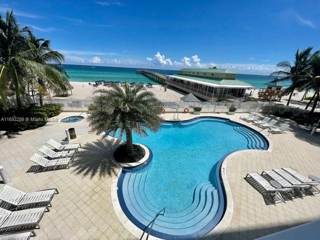 view of swimming pool with a patio and a water view