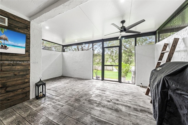 unfurnished sunroom with ceiling fan and a healthy amount of sunlight