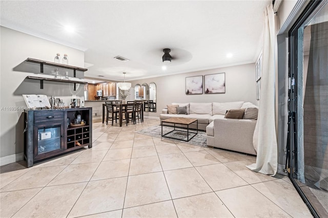 living room with ceiling fan, light tile patterned flooring, and ornamental molding