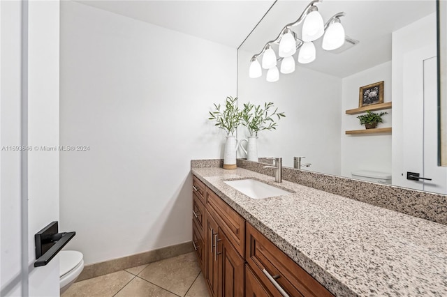 bathroom with tile patterned flooring, vanity, and toilet