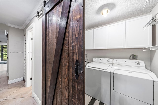 laundry area with cabinets, crown molding, a textured ceiling, light tile patterned flooring, and washer and dryer