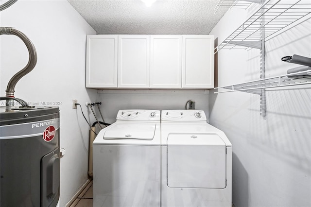 laundry area with washer and dryer, cabinets, electric water heater, and a textured ceiling