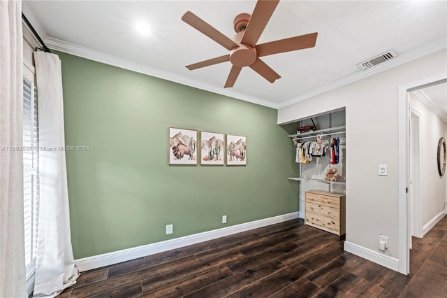 unfurnished bedroom with ceiling fan, crown molding, dark wood-type flooring, and a closet