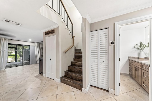 stairs featuring tile patterned floors and ornamental molding