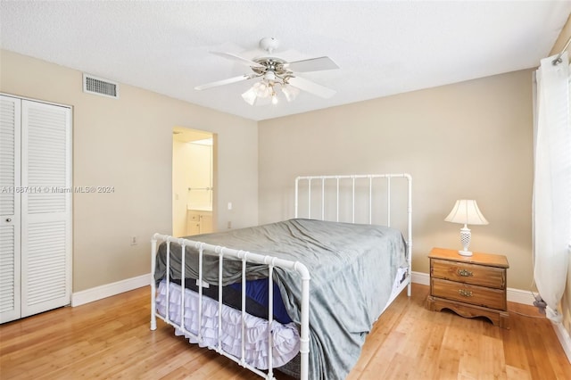 bedroom featuring hardwood / wood-style floors, a closet, ceiling fan, and ensuite bathroom