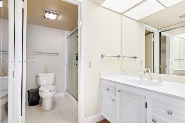 bathroom featuring tile patterned floors, vanity, toilet, and walk in shower