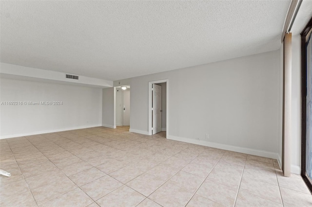 tiled empty room with a textured ceiling