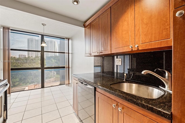 kitchen with dark stone counters, sink, pendant lighting, light tile patterned floors, and dishwasher