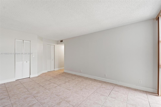 tiled spare room with a textured ceiling