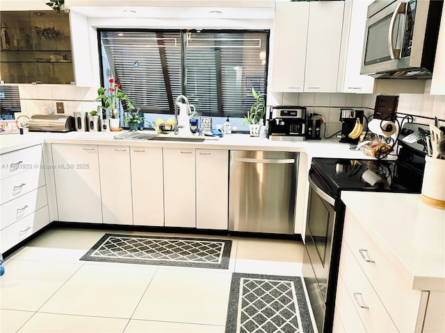 kitchen with white cabinets, sink, light tile patterned floors, and stainless steel appliances