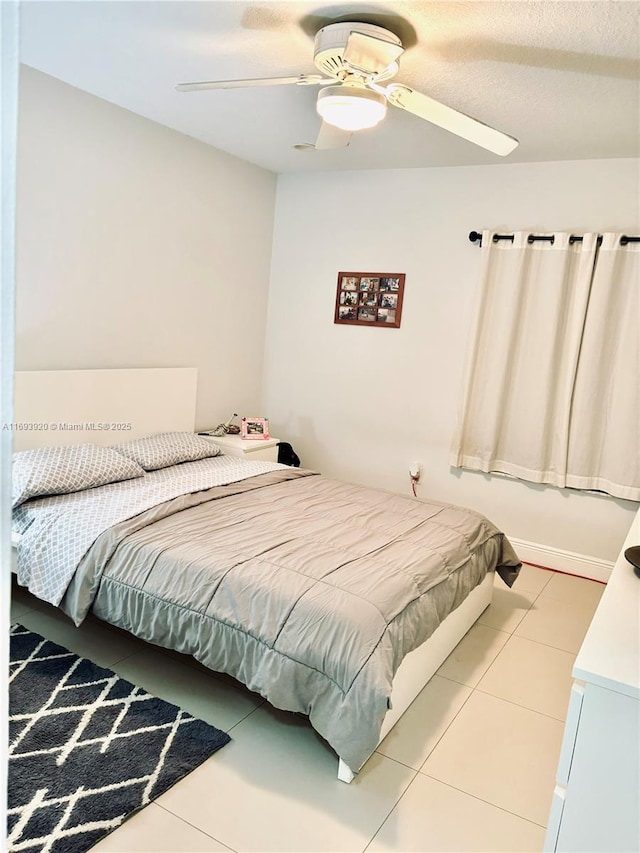 tiled bedroom featuring ceiling fan