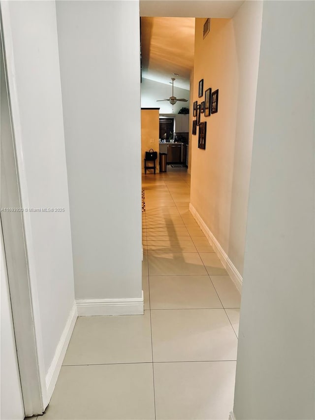 hall featuring tile patterned flooring and lofted ceiling