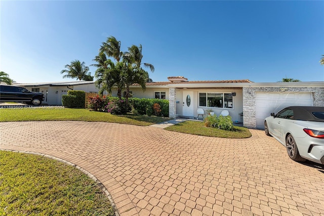 ranch-style home featuring a garage and a front yard