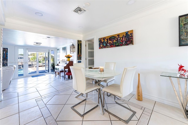 tiled dining space with ornamental molding and french doors