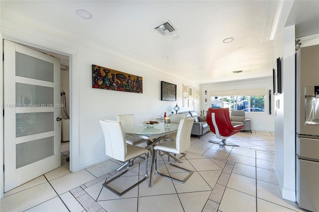 tiled dining room featuring ornamental molding