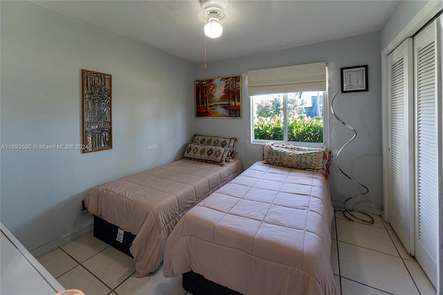 tiled bedroom featuring ceiling fan and a closet