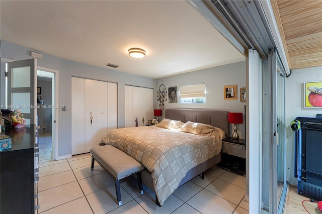 tiled bedroom featuring multiple closets