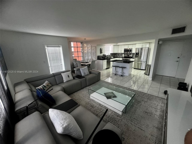 living room with light tile patterned floors and an inviting chandelier