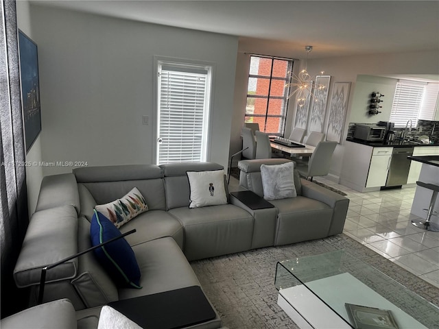 living room featuring light tile patterned floors, a notable chandelier, and sink