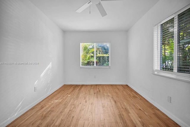 empty room featuring light wood-type flooring, ceiling fan, and a healthy amount of sunlight