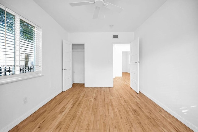 unfurnished bedroom featuring ceiling fan, light hardwood / wood-style floors, and a closet