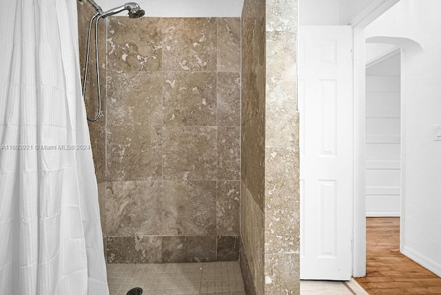 bathroom with wood-type flooring and curtained shower