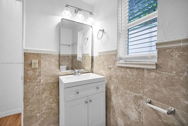 bathroom with vanity and tile walls