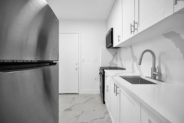 kitchen with sink, white cabinets, and stainless steel appliances