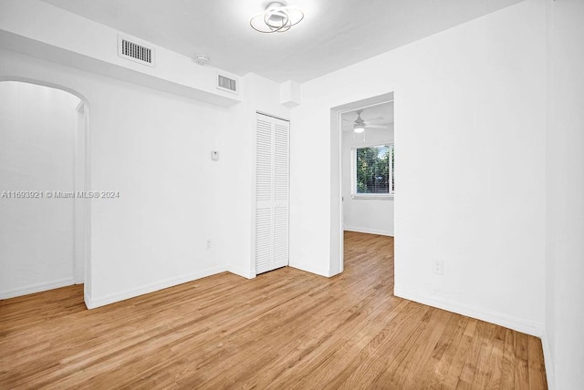 empty room with light wood-type flooring and ceiling fan