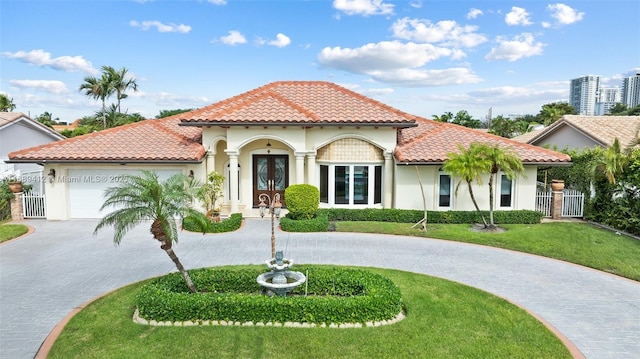 mediterranean / spanish-style house with a garage, a front lawn, and french doors